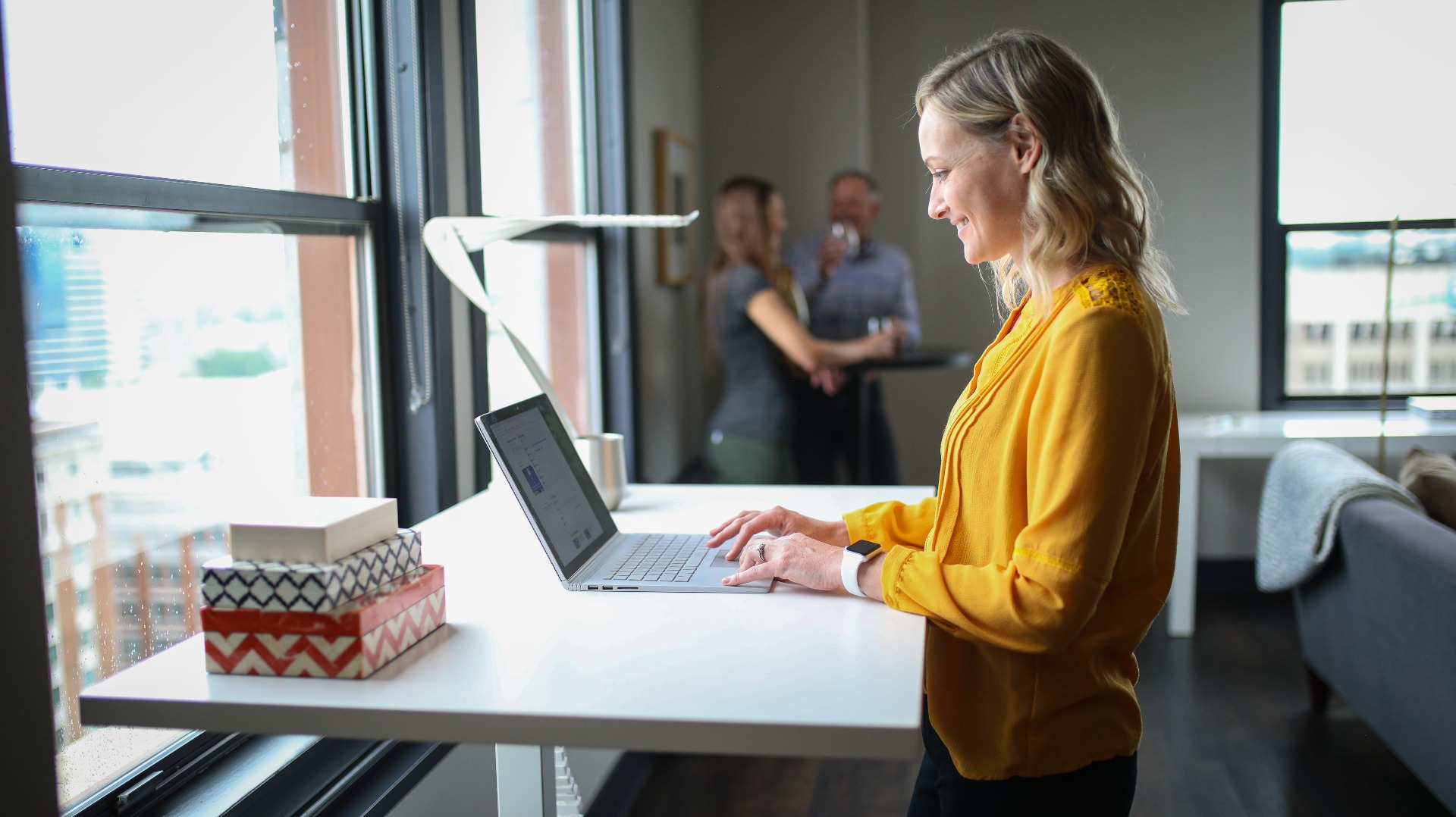 Woman smiling at a standing desk